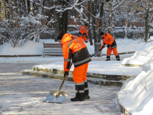 Crew Removing Snow From Sidewalk