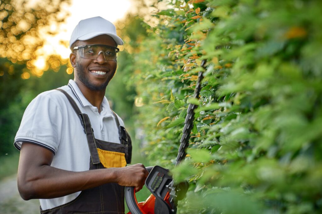 Landscaper with hedge trimmer. 