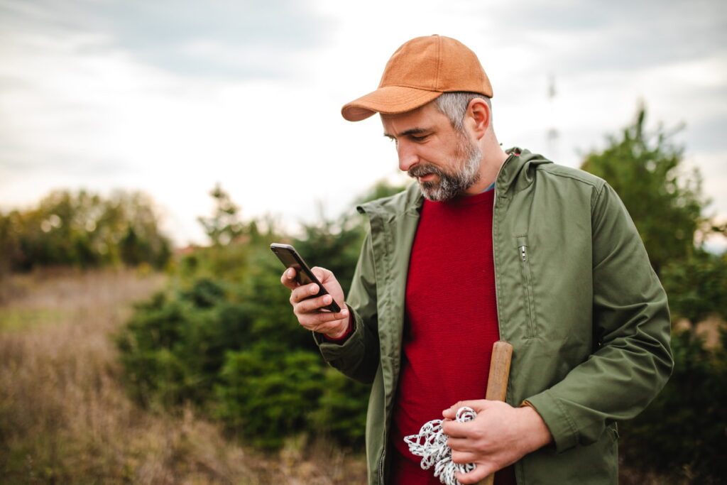Man in field looking at phone